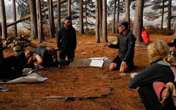 a group of gap year students sit and listen to an instructor on an outdoor educator expedition with outward bound